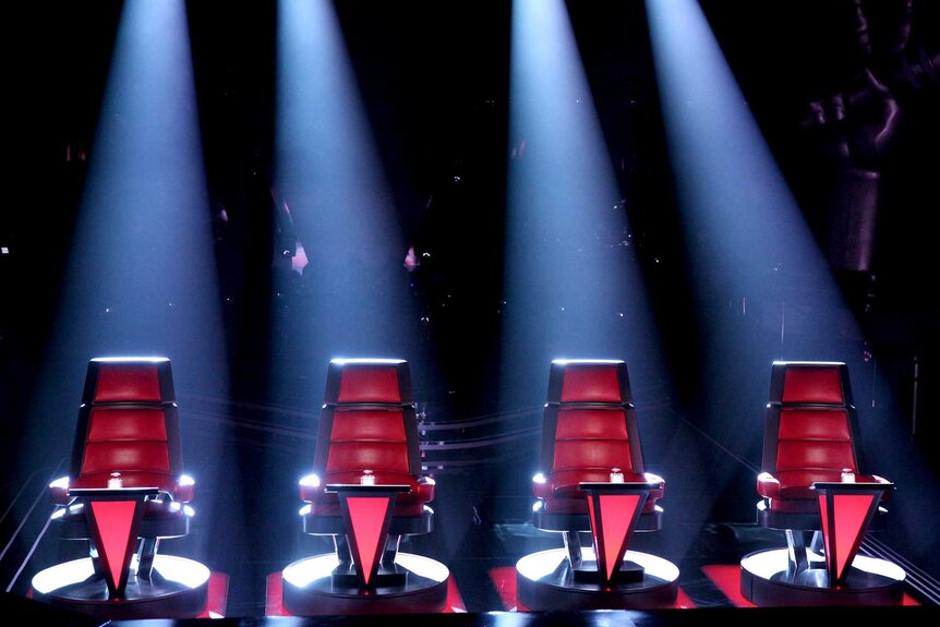 A photo of the coaches' chairs on The Voice under spotlights