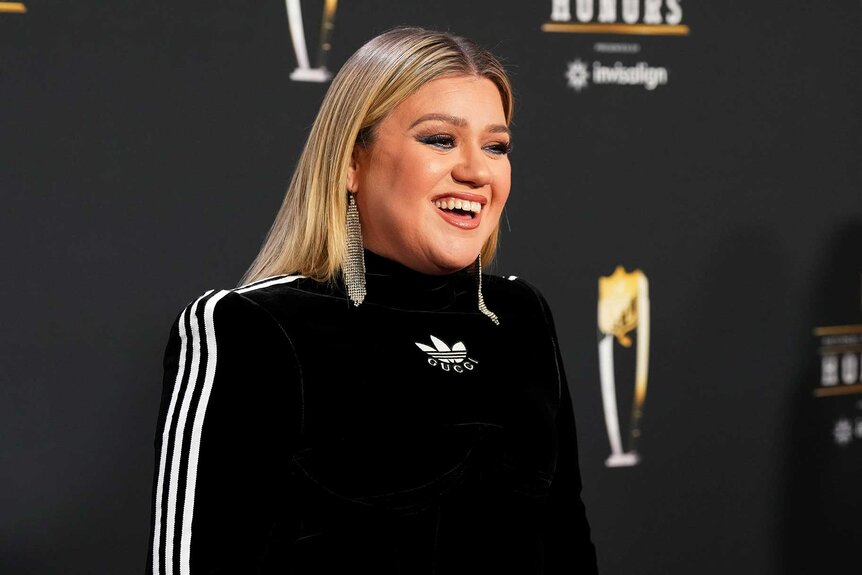 Kelly Clarkson posing for photos at the NFL Honors.