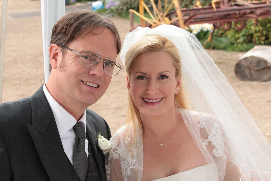 Dwight Schrute and Angela Martin in wedding attire in a scene from The Office.