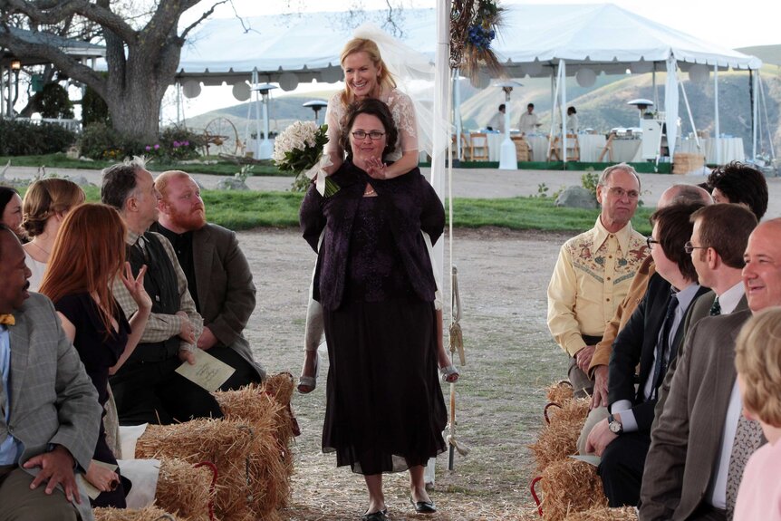 Phyllis Vance and Angela Martin walking down the aisle in a scene from The Office.