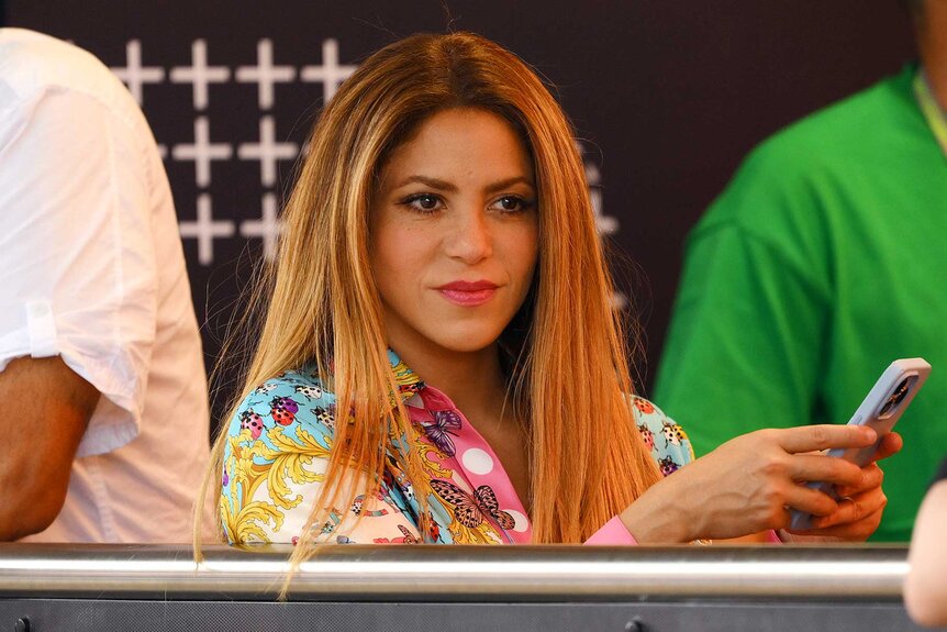 Shakira holding her cell phone.