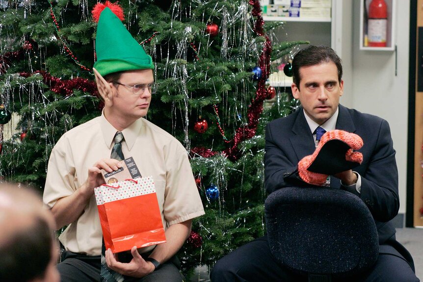 Dwight Schrute and Michael Scott in Christmas outfits.