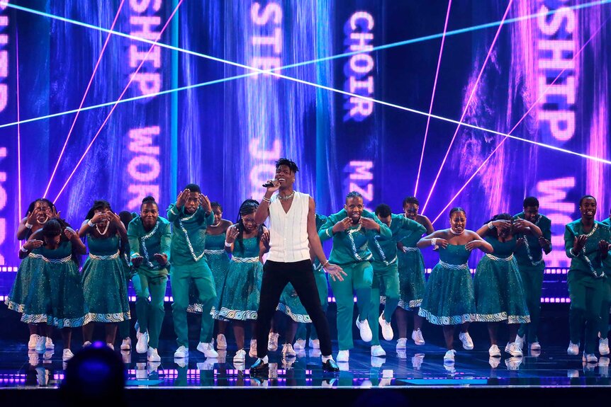 Jon Batiste singing on stage with Mzansi Youth Choir during America's Got Talent.