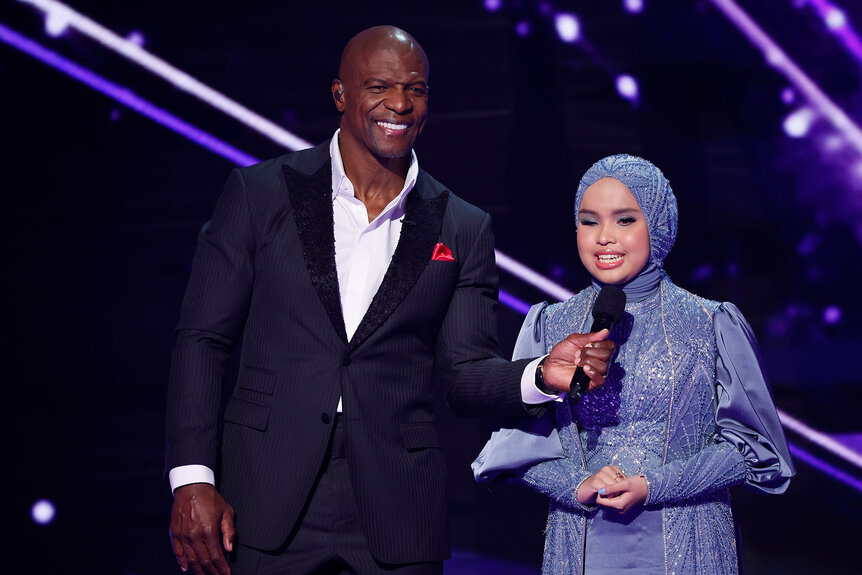 Putri Ariani stands onstage with Terry Crews during the Season 18 Finale of America’s Got Talent