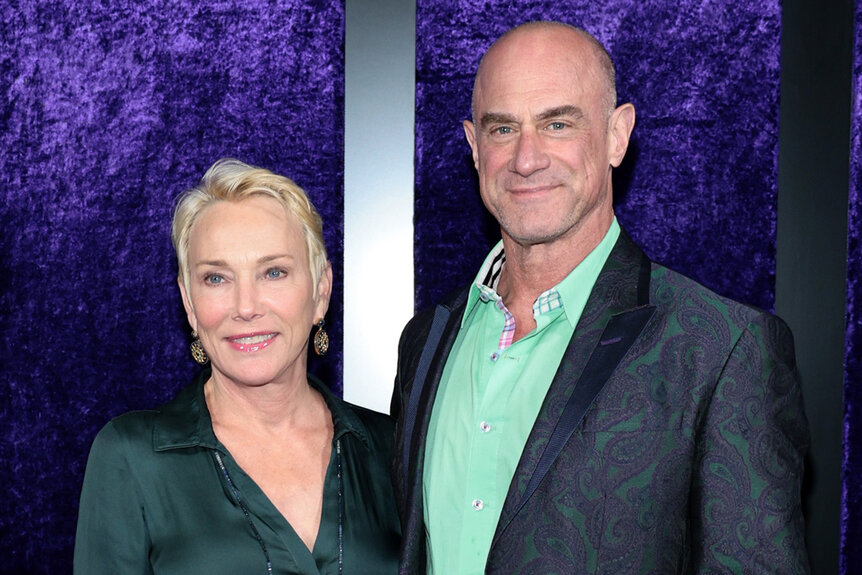 Chris Meloni next to his wife Sherman Williams smiling on a red carpet