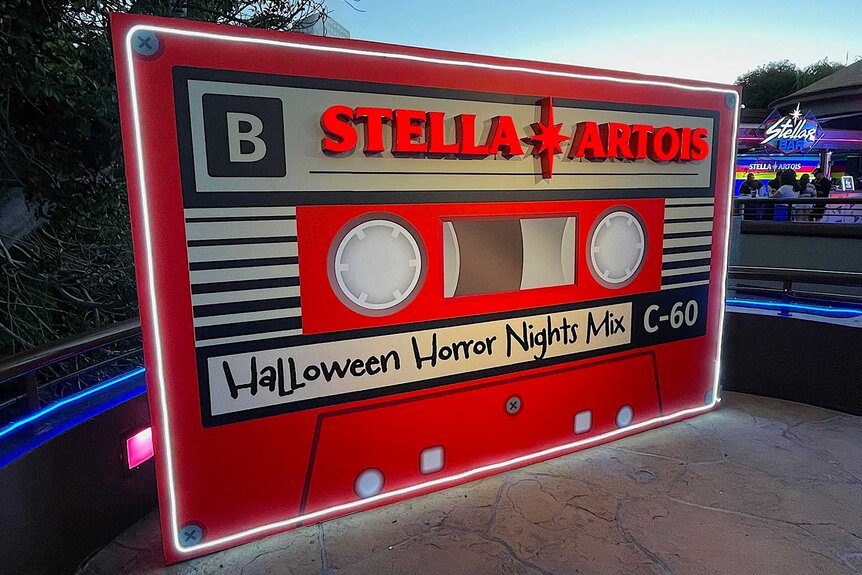 An oversized red cassette tape that has Halloween Horror Nights Mix written on it.
