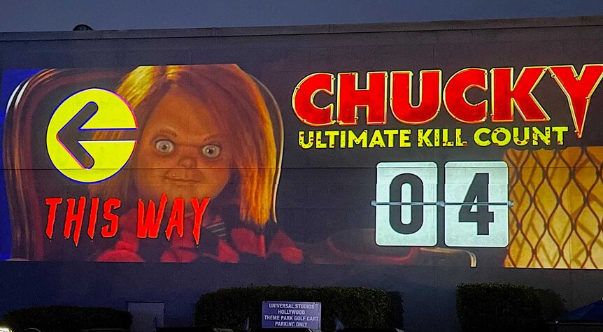 A billboard of Chucky that leads guests to the direction of the haunted house.