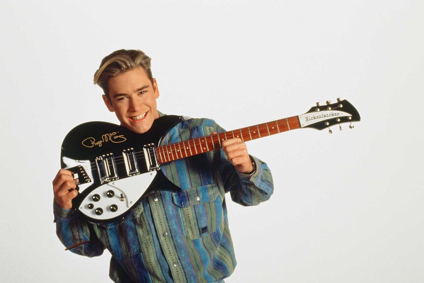 Zack Morris holding a guitar for a promotional photo for Saved By The Bell.