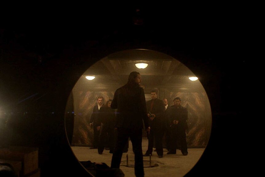 Frankie appears in a tunnel with a group of people in front of him.