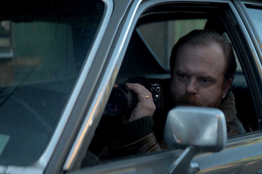 Mayhew appears spying on someone in a car during a scene from The Continental.