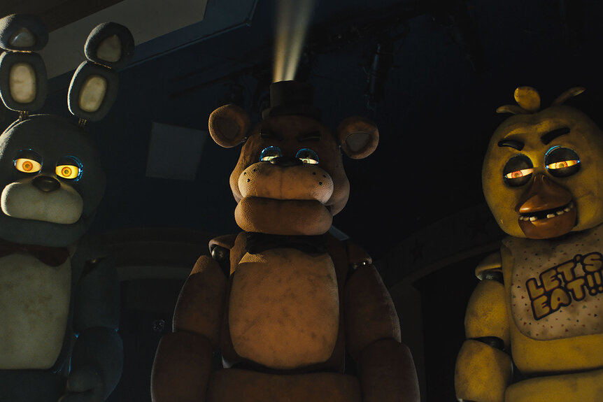 Bonnie, Freddy Fazbear and Chica stand together while looking down at something in Five Nights at Freddy's
