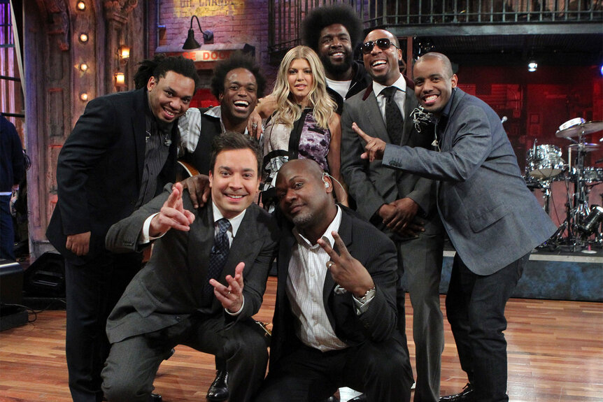 The Roots, Jimmy Fallon, and Fergie pose for a photo together