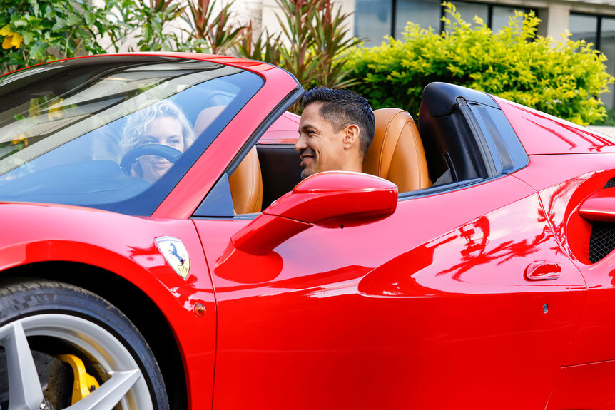 Jay Hernandez as Thomas Magnum sits in his red corvette