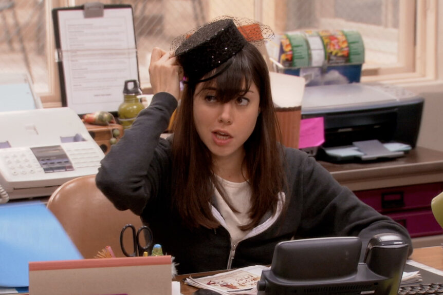 April Ludgate wearing a hat at her desk on Parks And Recreation episode 313