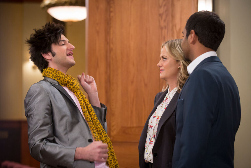 Ben Schwartz as Jean-Ralphio Saperstein, Amy Poehler as Leslie Knope, and Aziz Ansari as Tom Haverford stand together