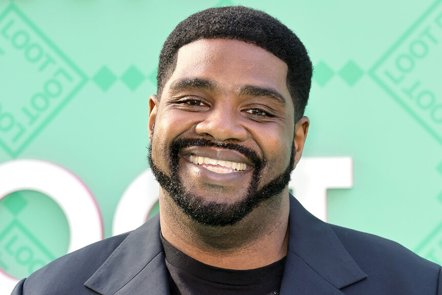 Ron Funches smiles on the red carpet for an event