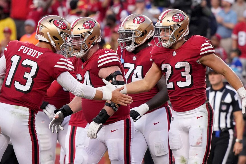 The San Francisco 49ers celebrate together on the field