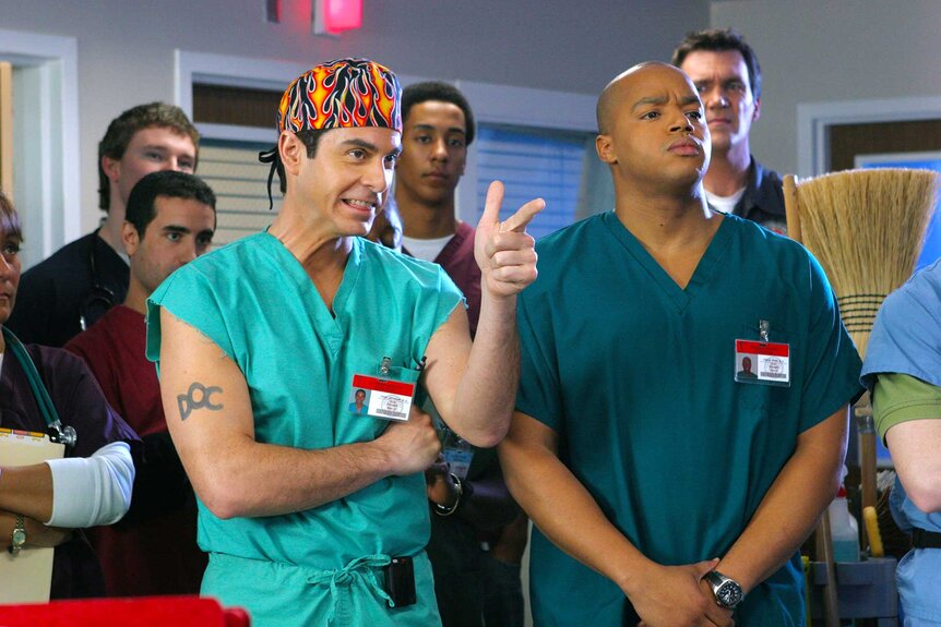 Dr. Todd Quinlan standing next to Dr. Christopher Turk while holding up a finger gun.