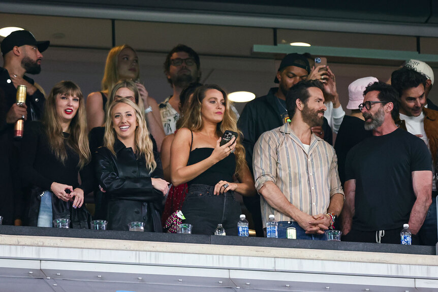 Taylor Swift, Brittany Mahomes, Blake Lively, Hugh Jackman, and Ryan Reynolds watch from the stands during an NFL football game