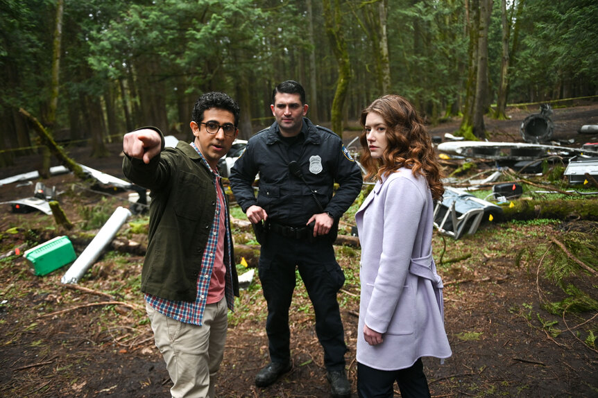 Rizwan and Phoebe standing with a character outside in the forest while Rizwan points into the distance.
