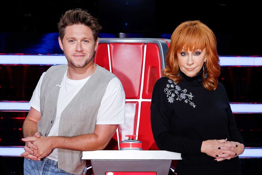 Niall Horan and Reba McEntire pose together at their coaches chair on The Voice episode 2410