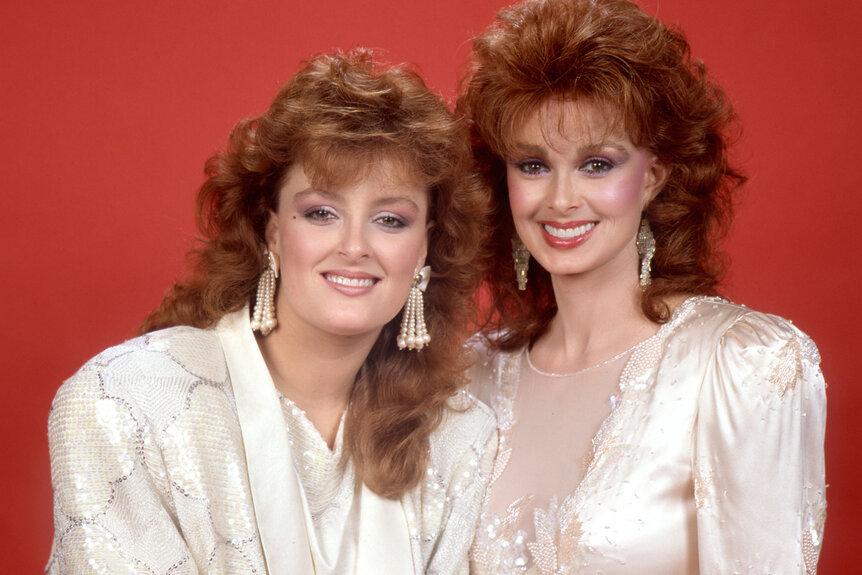 Wynonna Judd and Naomi Judd pose together in matching white outfits
