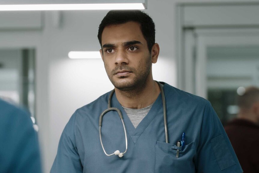 Dr. Bashir Hamed wearing blue scrubs and a stethoscope around his neck.