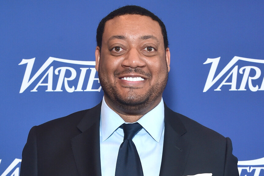 Cedric Yarbrough smiles on the red carpet at an event