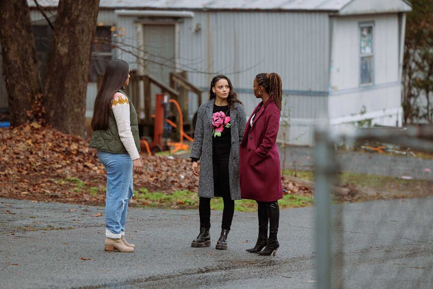 Lacey Quinn and Gabi Mosely having a conversation with another character outside.