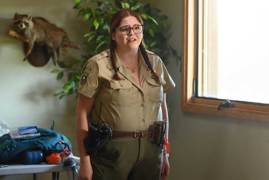 Lisa dressed as a park ranger standing in a room.