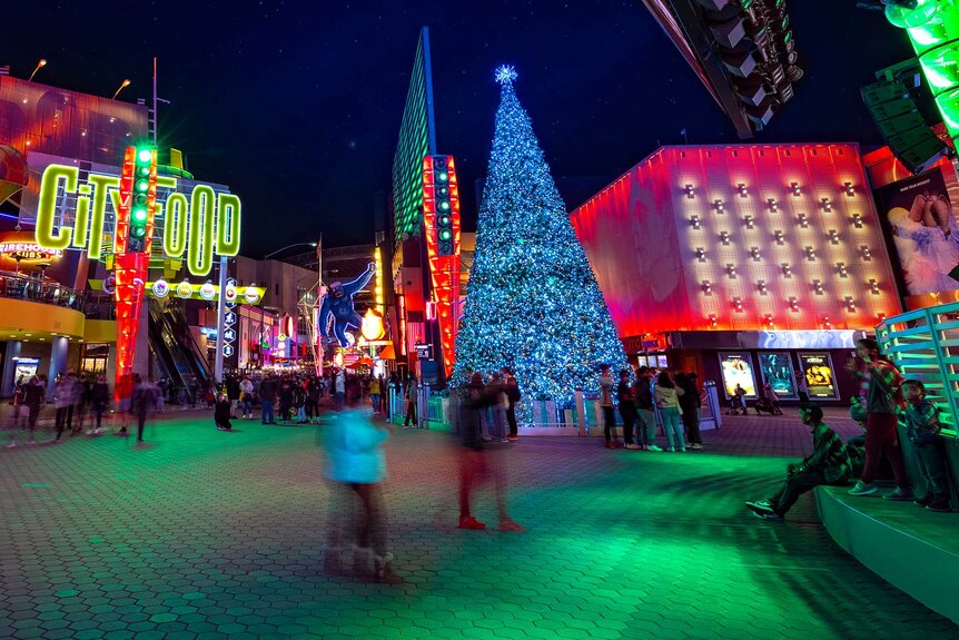 Guests walking around Universal CityWalk Hollywood with a Christmas tree in the background.