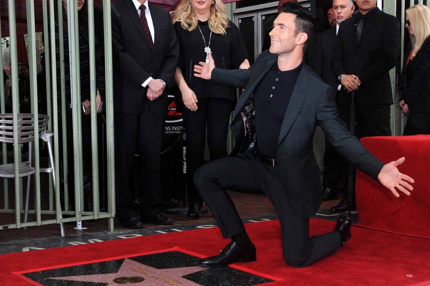 Adam Levine poses with his star on the Hollywood Walk of Fame.