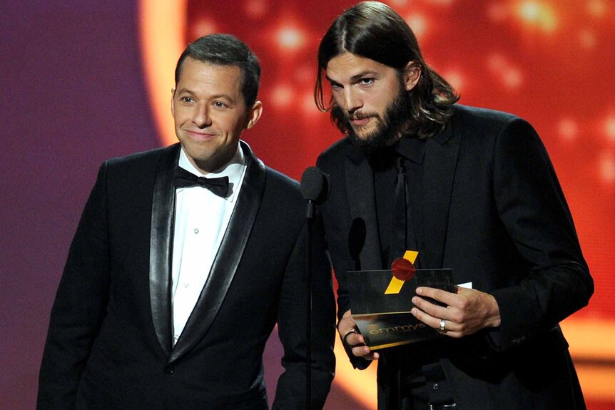 Jon Cryer and Ashton Kutcher speak onstage during the 63rd Annual Primetime Emmy Awards