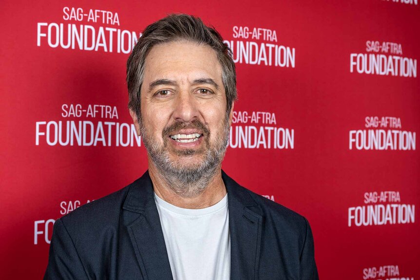 Ray Romano smiles in a blazer and T-shirt.