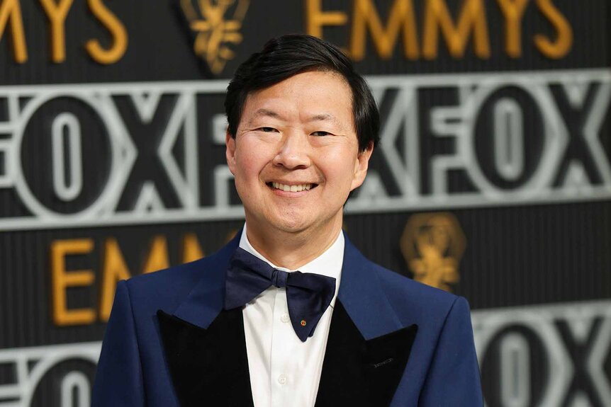 Ken Jeong smiles in a suit and bowtie.