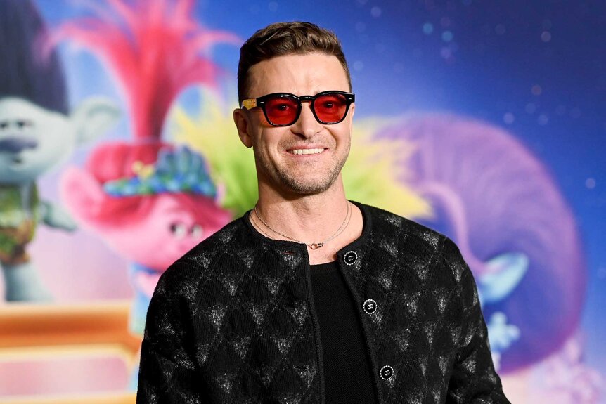 Justin Timberlake wears glasses and a printed jacket on the red carpet for trolls band together
