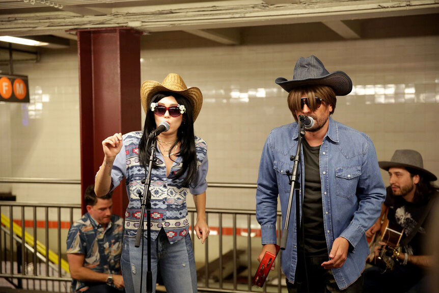 Miley Cyrus and Jimmy Fallon wear disguises as they perform in the New York City subway