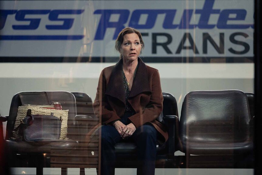 Margaret Reed sits in a bus station in Found Episode 113.