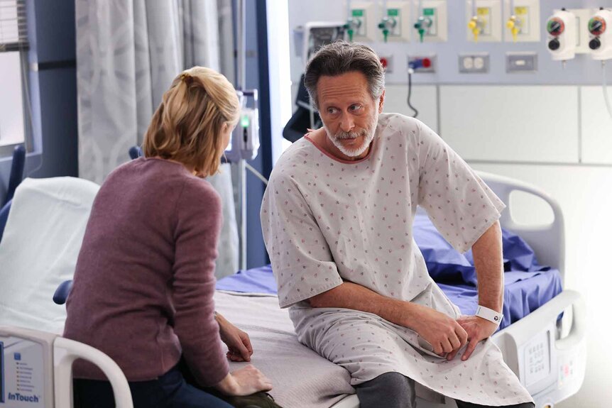 Dr. Hannah Asher and Dr. Dean Archer talk on a hospital bed in Chicago Med Episode 902.