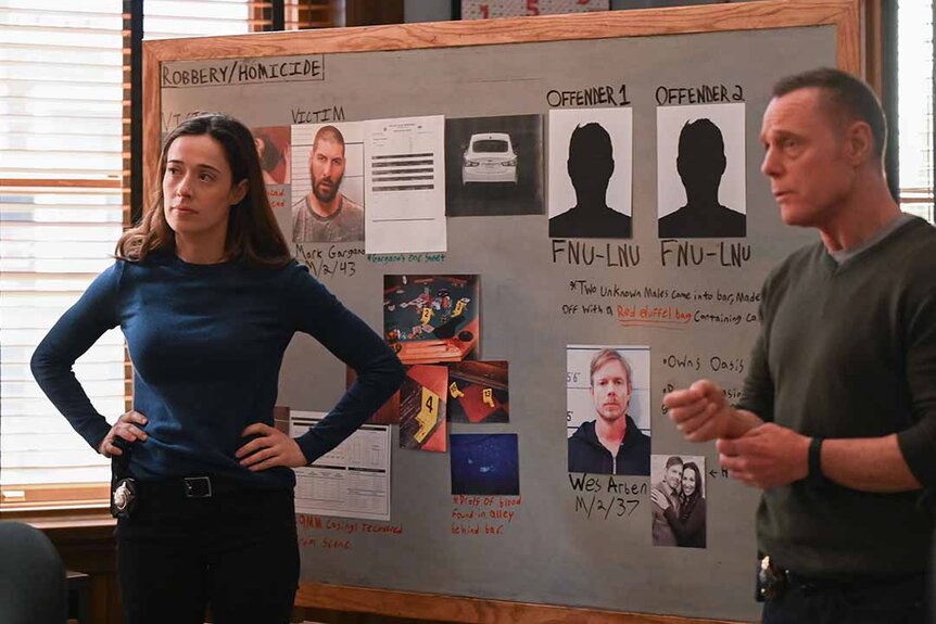 Kim Burgess and Hank Voight stand in front of an investigation board in Chicago P.D. Episode 1102