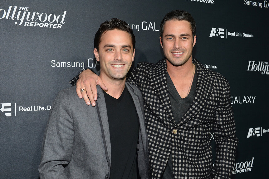 Taylor kinney with his arm over his brother Trent Kinney's shoulder