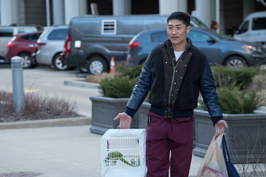 Ethan Choi carries his parrot in a cage