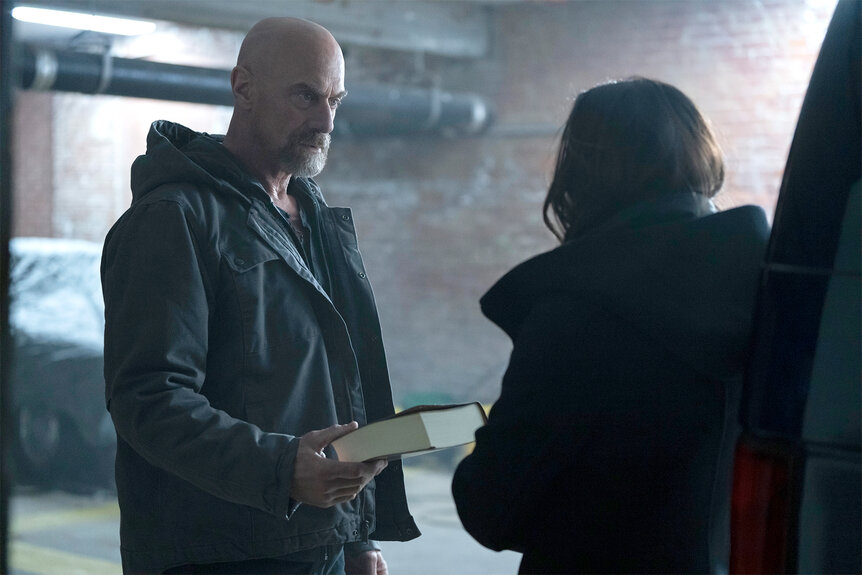 Elliot Stabler hands over a book on Law And Order organized crime Episode 405