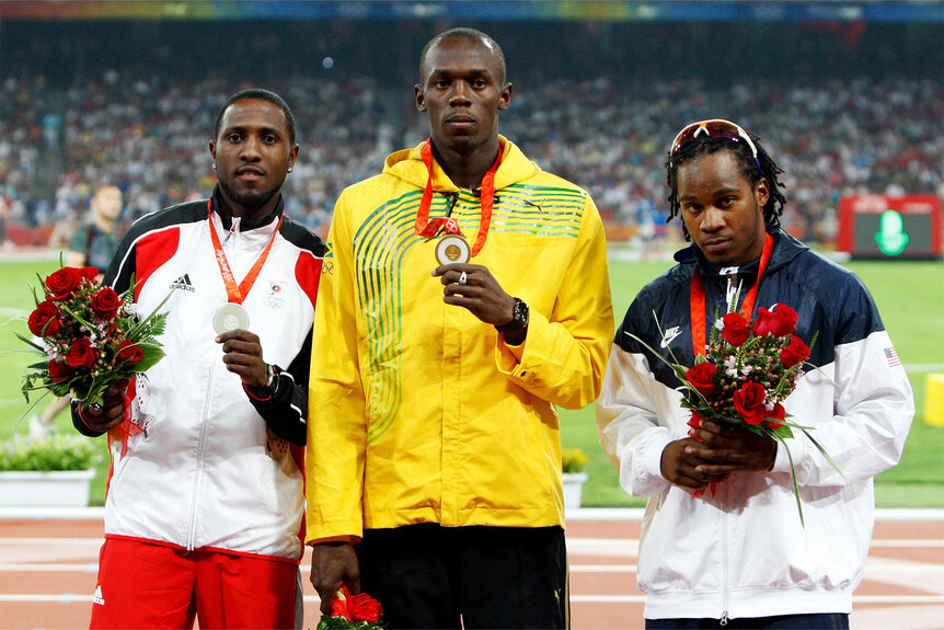 Silver medalist Richard Thompson, gold medalist Usain Bolt and bronze medalist Walter Dix stand on the podium during the medal ceremony for the Men's 100m Final in Beijing