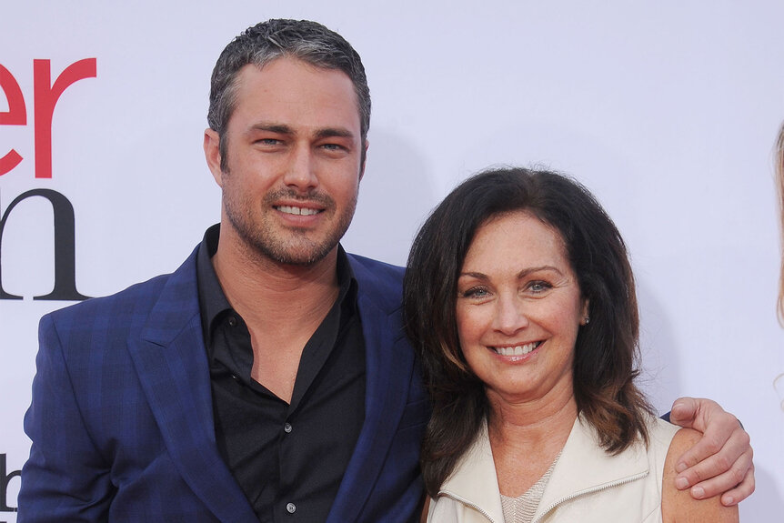 Taylor Kinney and mom Pamela Heisler embrace on the red carpet at the Los Angeles premiere of "The Other Woman"