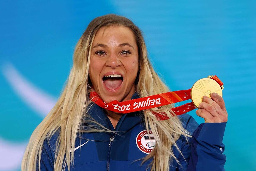 Oksana Masters holds up her gold medal.