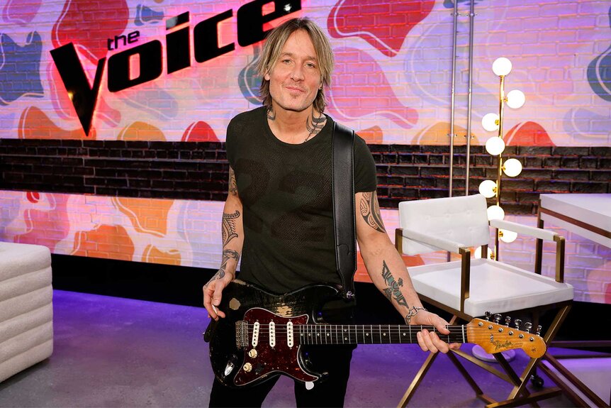 Keith Urban holds a guitar on The Voice episode 2422B