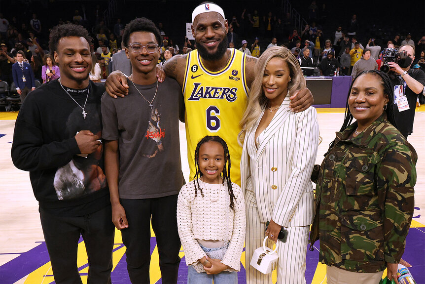 Lebron James poses with his wife, mother and 3 children at the end of a lakers game