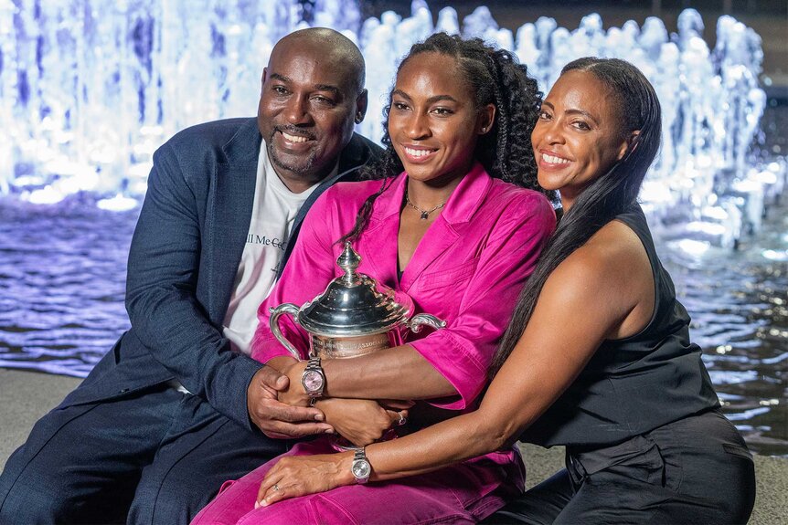Coco Gauff poses with her trophy with her Parents after the us open