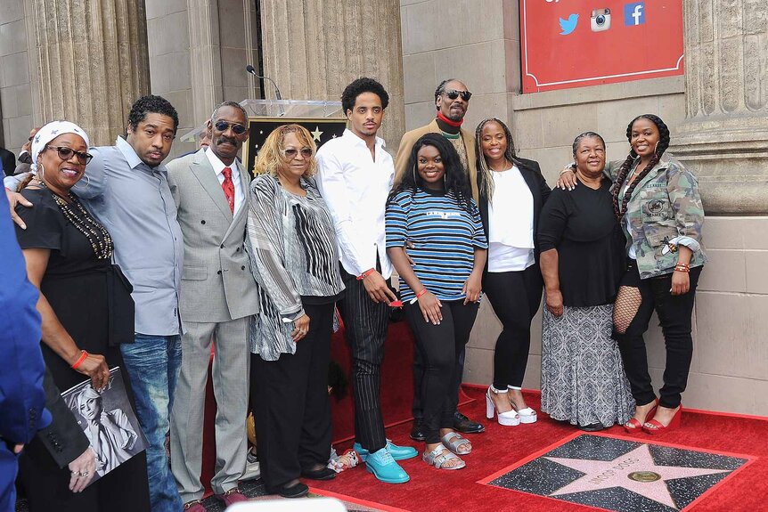 Snoop Dogg poses with family at his star on The Hollywood Walk of Fame.
